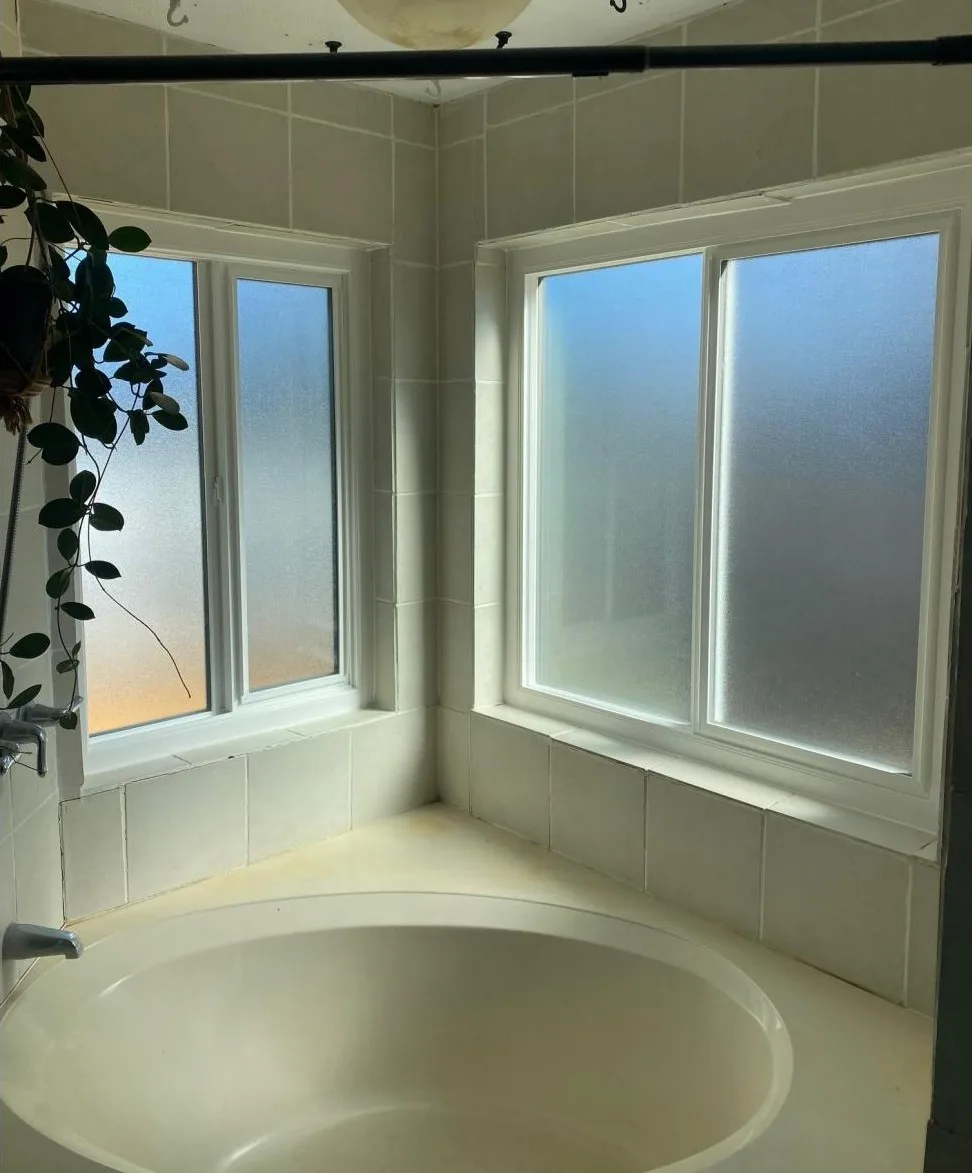 2 ventanas correderas con cristal esmerilado sobre una bañera de jardín