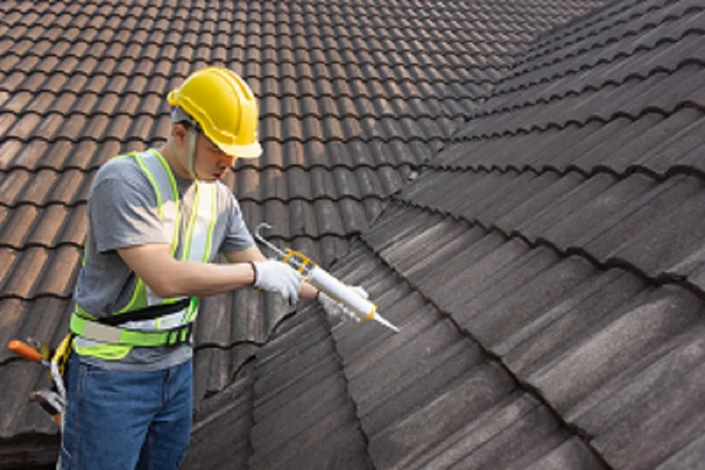 Roofer Sealing Roof Tiles with a silicon Sealant